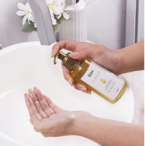 Foto do produto sendo usado na mao, pia do banheiro - cleansing oil da marca relax cosméticos