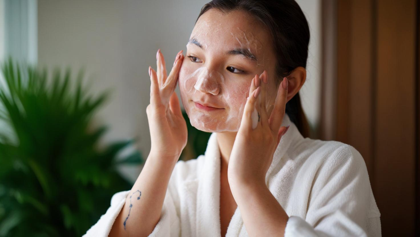 mulher asiática fazendo limpeza facial